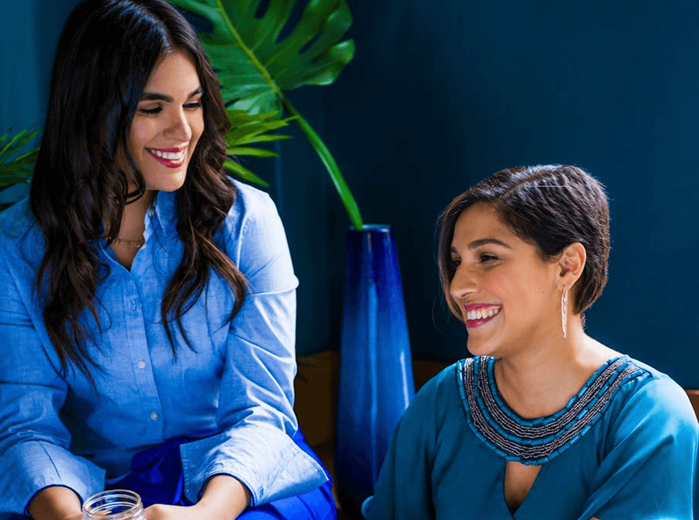 Two women chatting and smiling in a supportive online wellness forum